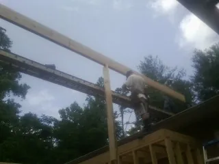 Carpenter setting a ridge beam over a new addition frame — Ice Dam Removal by Roofing Brothers in Bluffton